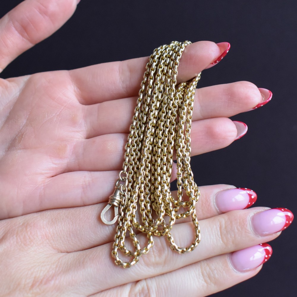 An antique 10ct yellow gold long guard chain featuring faceted oval links and a dog clip fastener. View XII