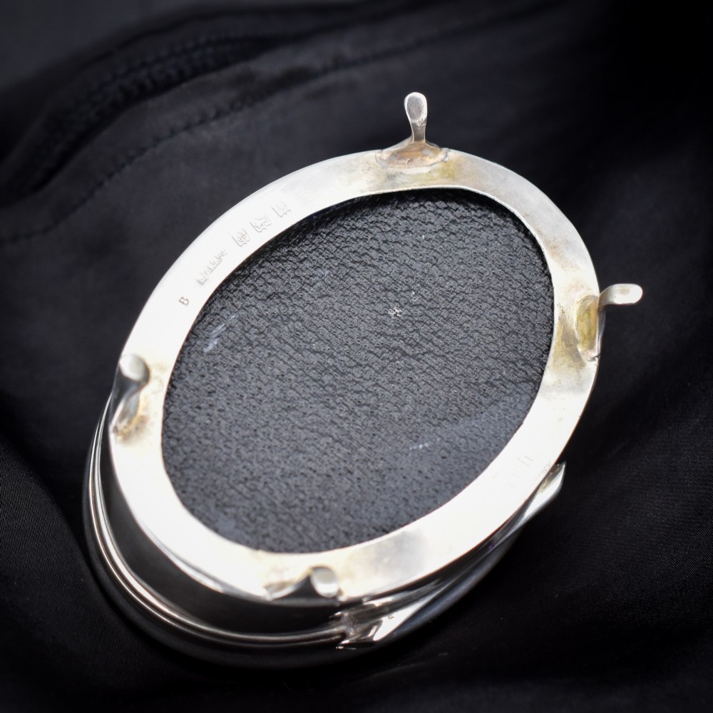 An oval sterling silver trinket box with a smooth polished hinged lid supported on four small cabriole feet. View III