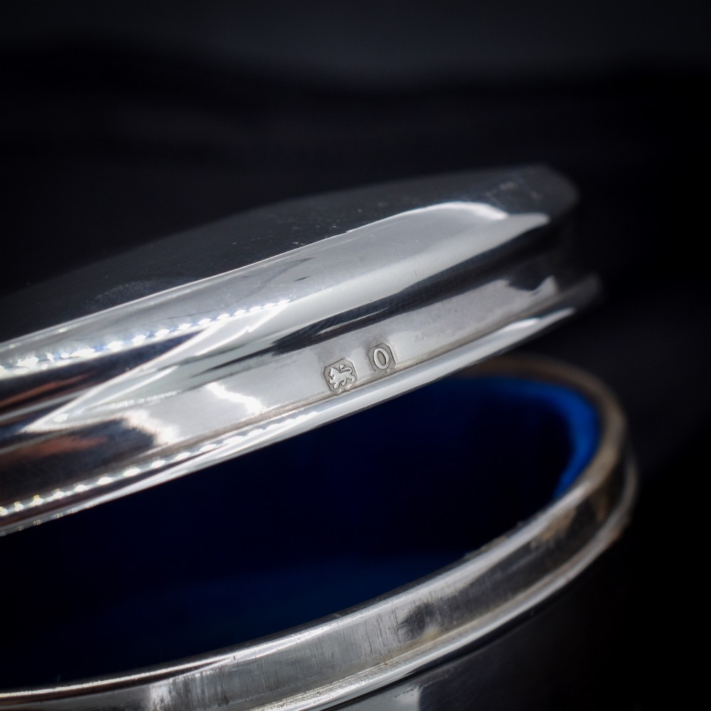 An oval sterling silver trinket box with a smooth polished hinged lid supported on four small cabriole feet. View VI