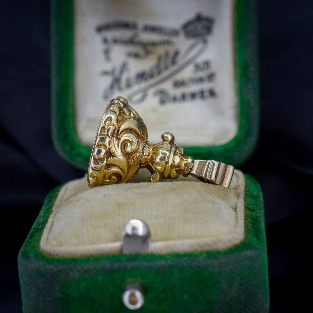 An oval orange-red carnelian gem carved with an intaglio mother bird motif, set within a chased gold-cased fob mount. View III