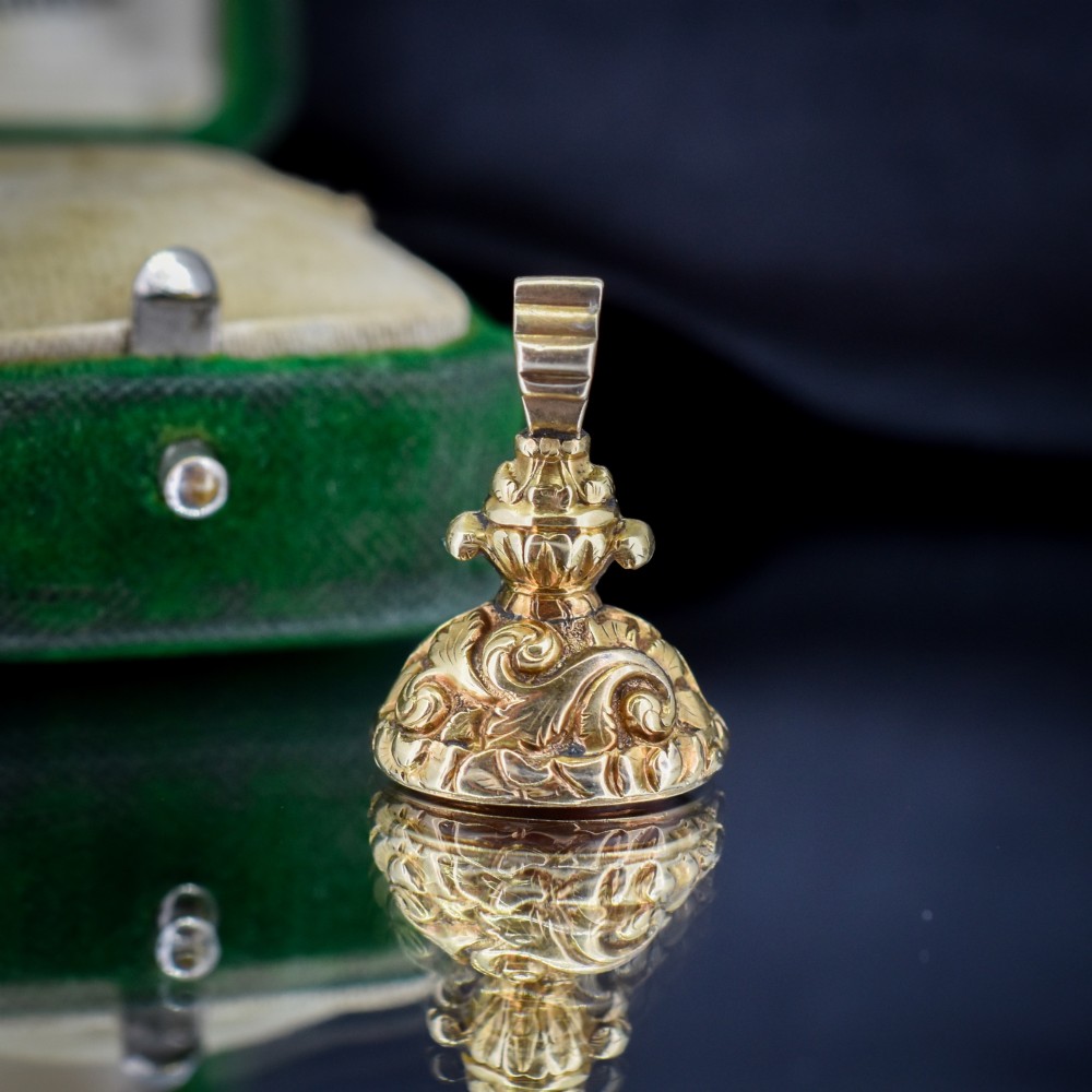 An oval orange-red carnelian gem carved with an intaglio mother bird motif, set within a chased gold-cased fob mount. View VIII