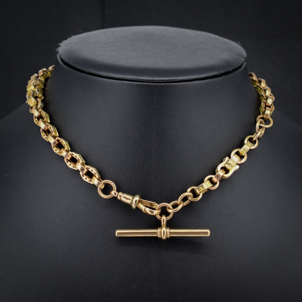 An antique 9ct yellow gold Albert watch chain with star engraved fancy links, a central T-bar, and a swivel dog clip fastener. View II