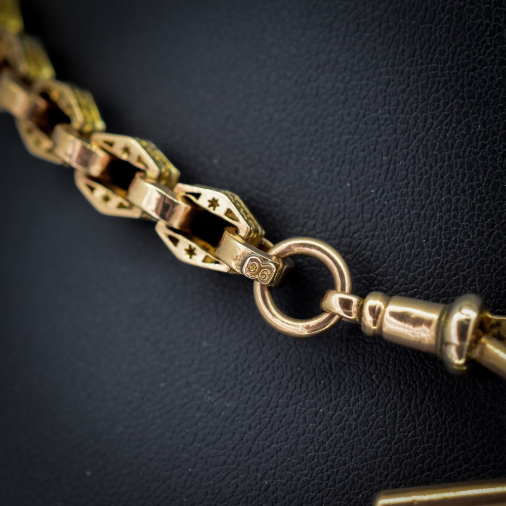 An antique 9ct yellow gold Albert watch chain with star engraved fancy links, a central T-bar, and a swivel dog clip fastener. View III