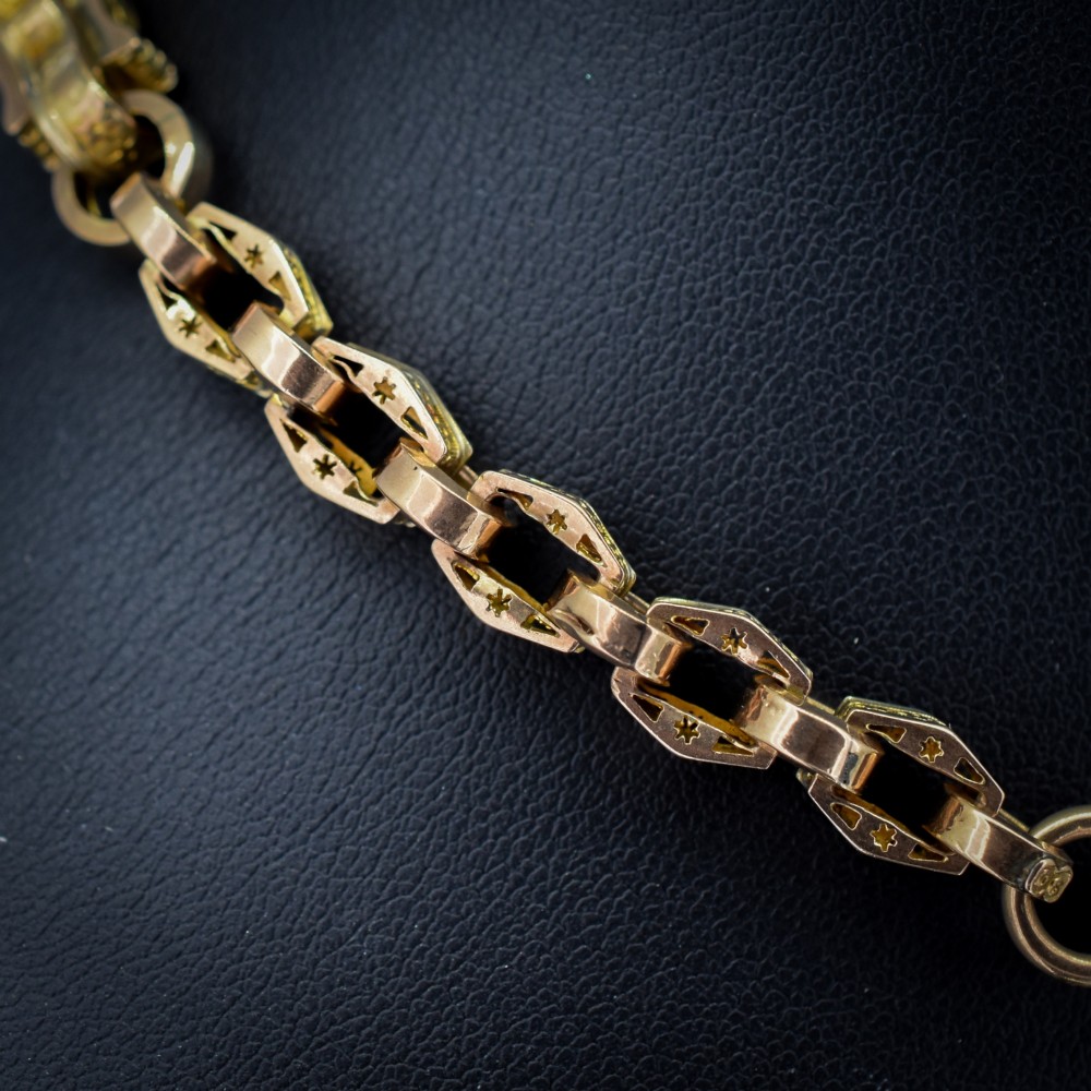 An antique 9ct yellow gold Albert watch chain with star engraved fancy links, a central T-bar, and a swivel dog clip fastener. View IV
