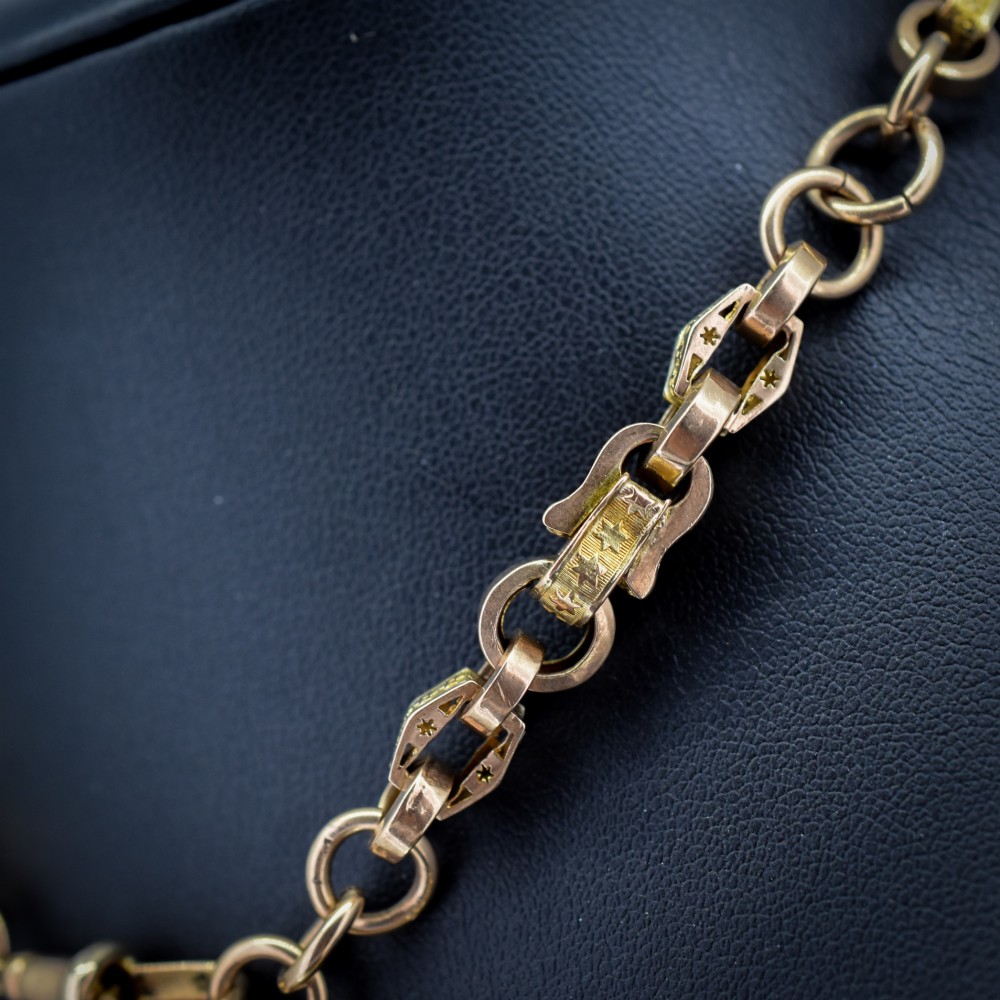 An antique 9ct yellow gold Albert watch chain with star engraved fancy links, a central T-bar, and a swivel dog clip fastener. View VI