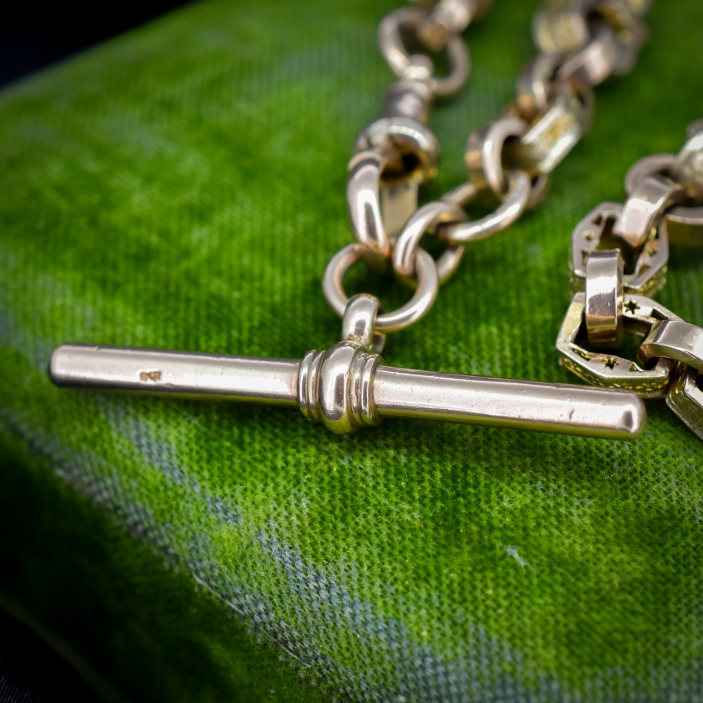 An antique 9ct yellow gold Albert watch chain with star engraved fancy links, a central T-bar, and a swivel dog clip fastener. View VII