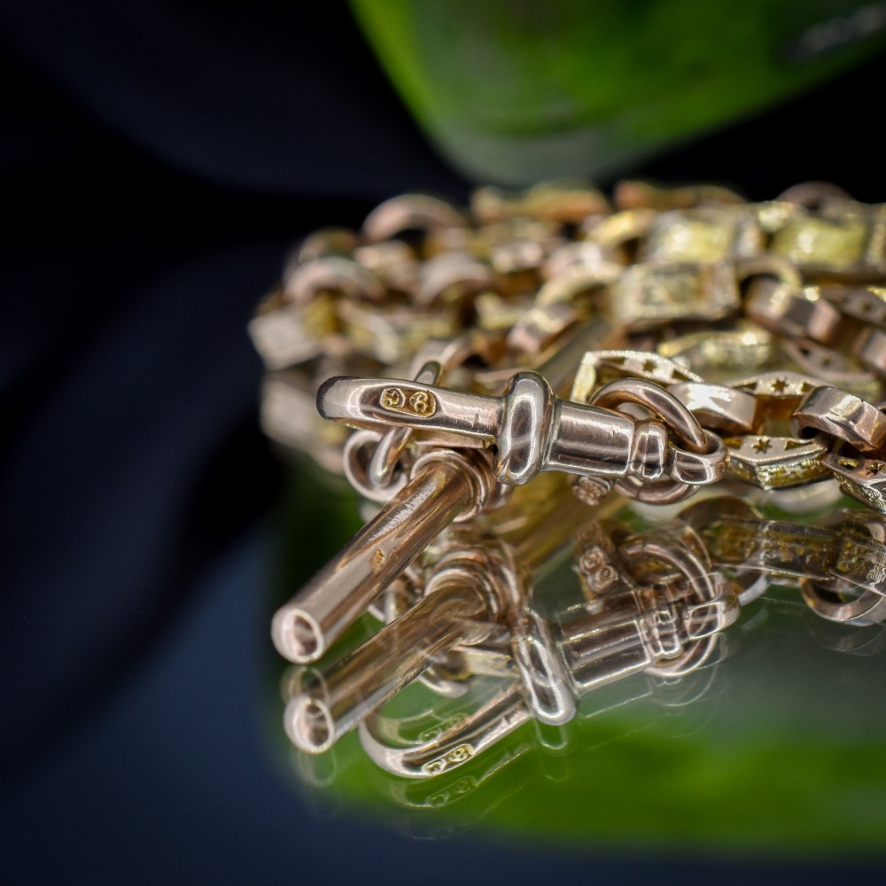 An antique 9ct yellow gold Albert watch chain with star engraved fancy links, a central T-bar, and a swivel dog clip fastener. View VIII