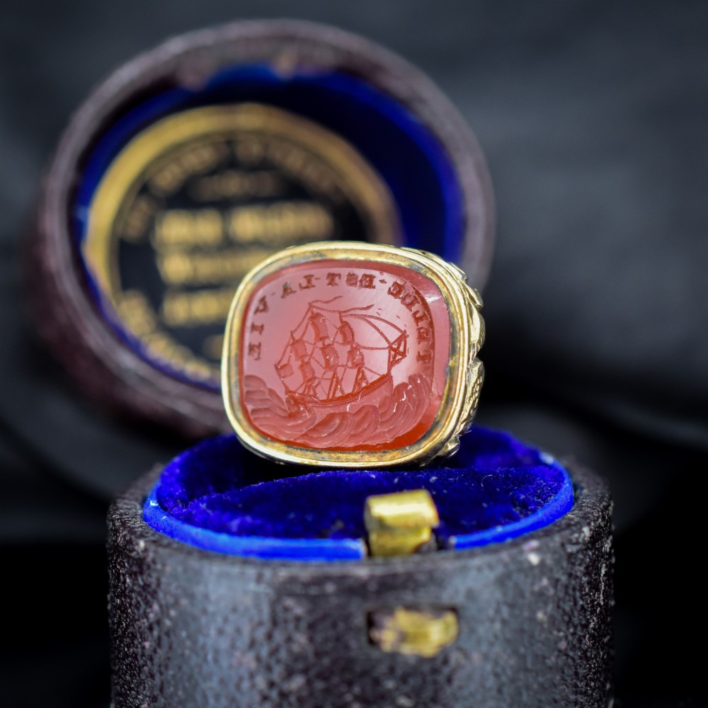A Georgian gold fob seal set with a red carnelian intaglio engraved with a sailing ship and the French inscription Telle Est La Vie.