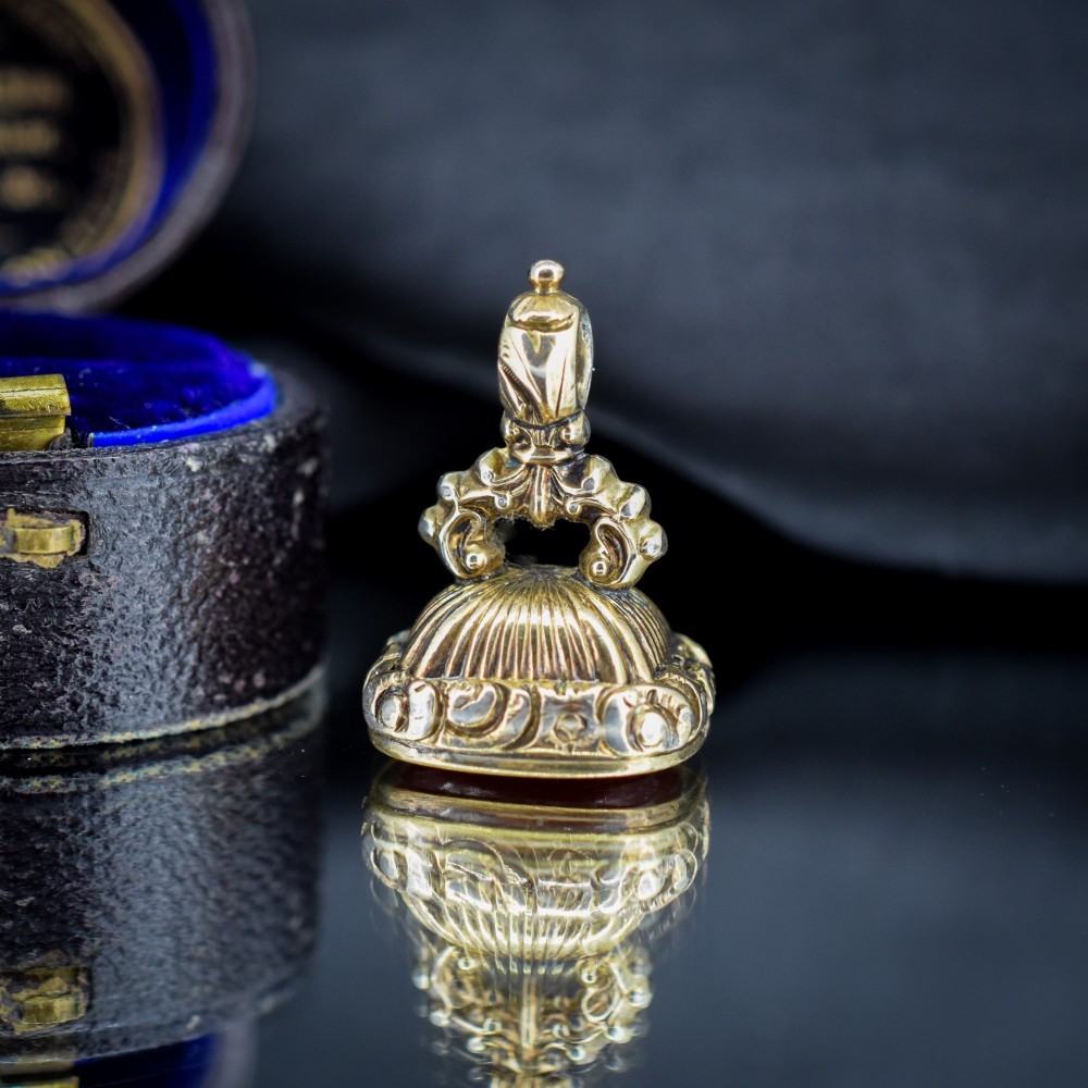 A Georgian gold fob seal set with a red carnelian intaglio engraved with a sailing ship and the French inscription Telle Est La Vie. View V