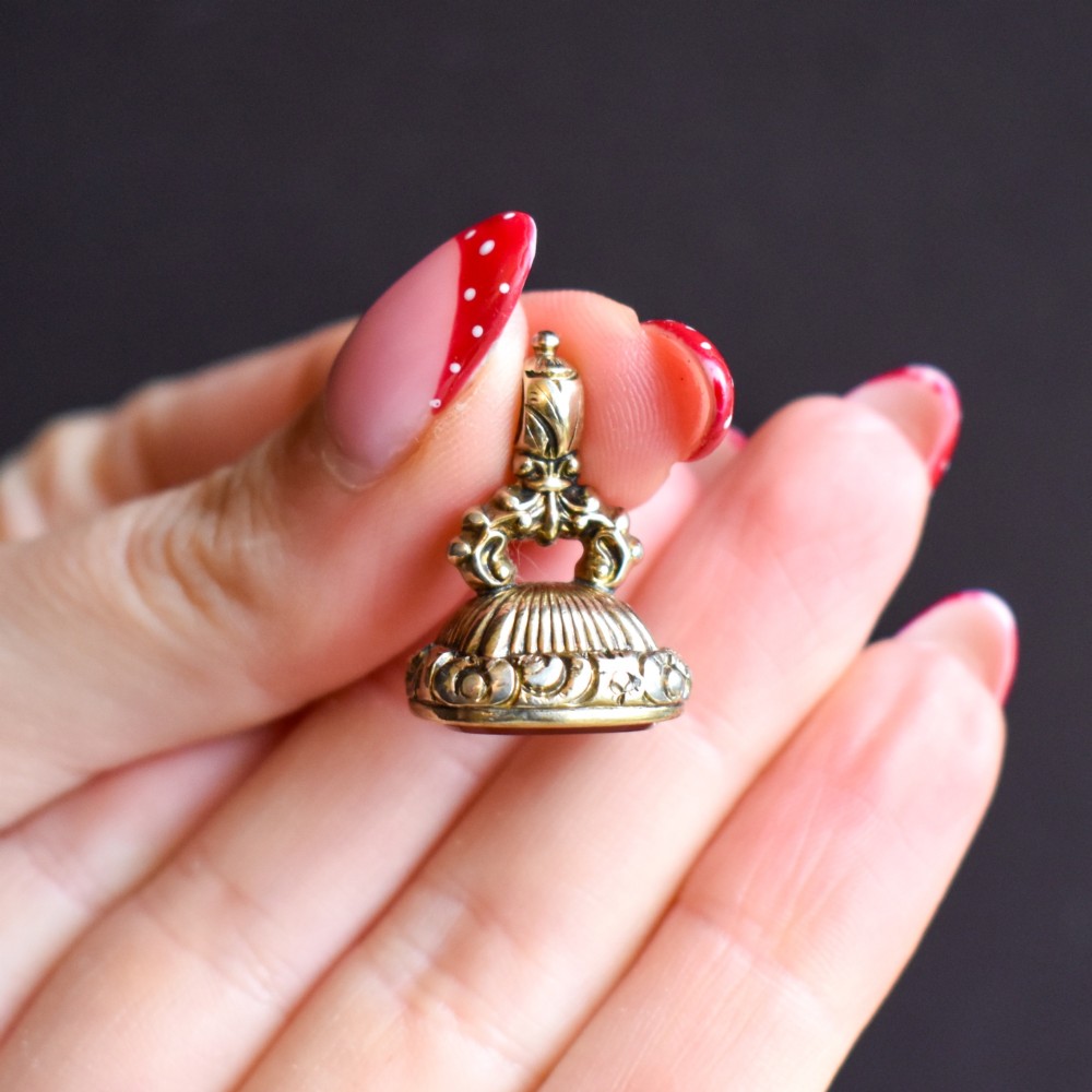 A Georgian gold fob seal set with a red carnelian intaglio engraved with a sailing ship and the French inscription Telle Est La Vie. View IX
