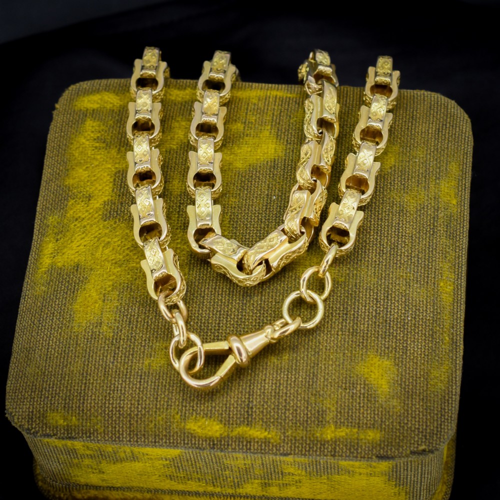 An antique 10ct yellow gold tulip link chain necklace featuring textured engraved links and a swivel dog clip clasp. View V