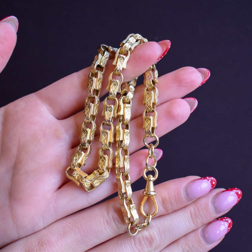 An antique 10ct yellow gold tulip link chain necklace featuring textured engraved links and a swivel dog clip clasp. View VIII
