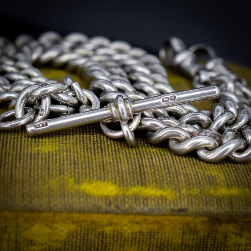 An antique sterling silver Albert watch chain featuring heavy curb links, double swivel clasps, and a central T-bar attachment. View V