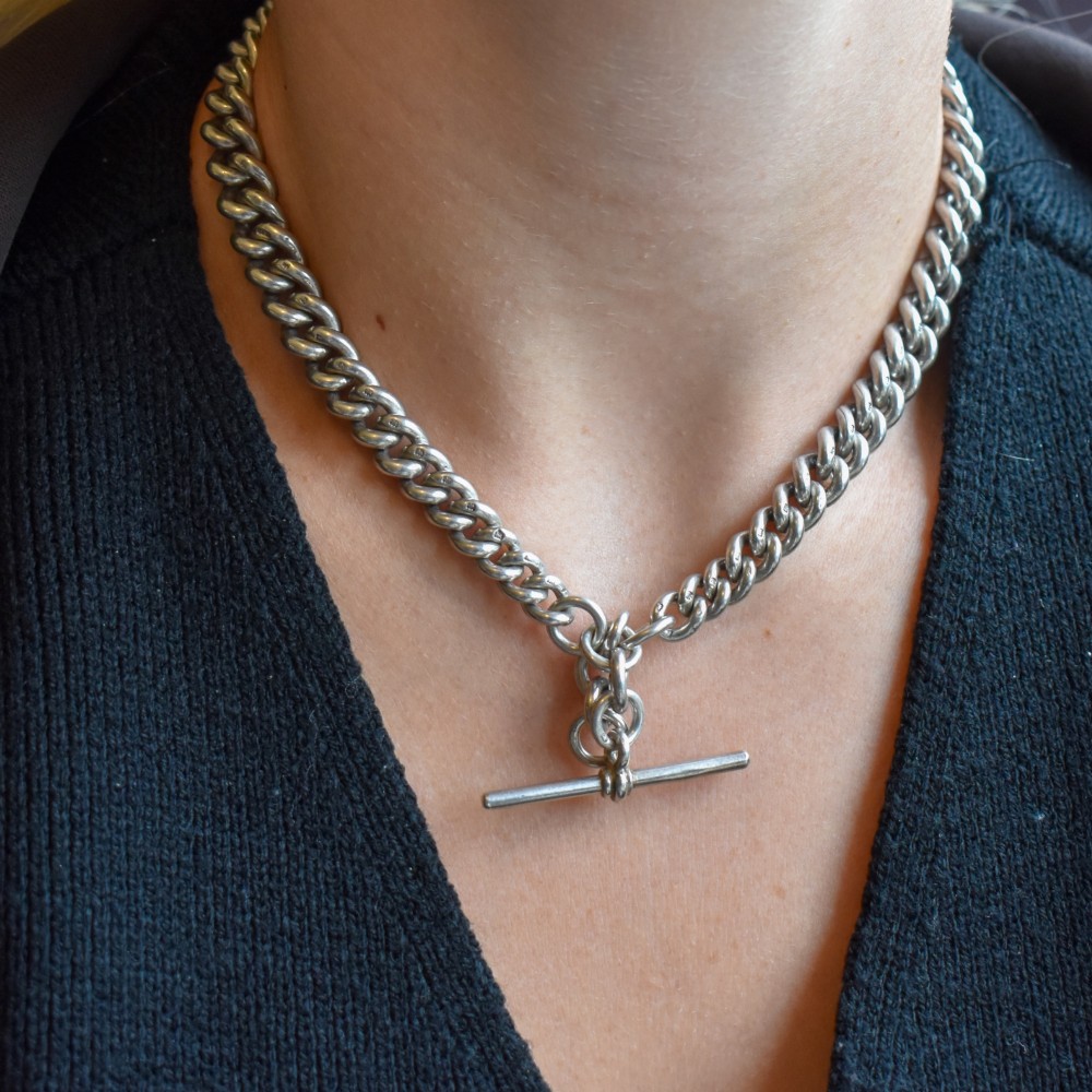 An antique sterling silver Albert watch chain featuring heavy curb links, double swivel clasps, and a central T-bar attachment. View IX
