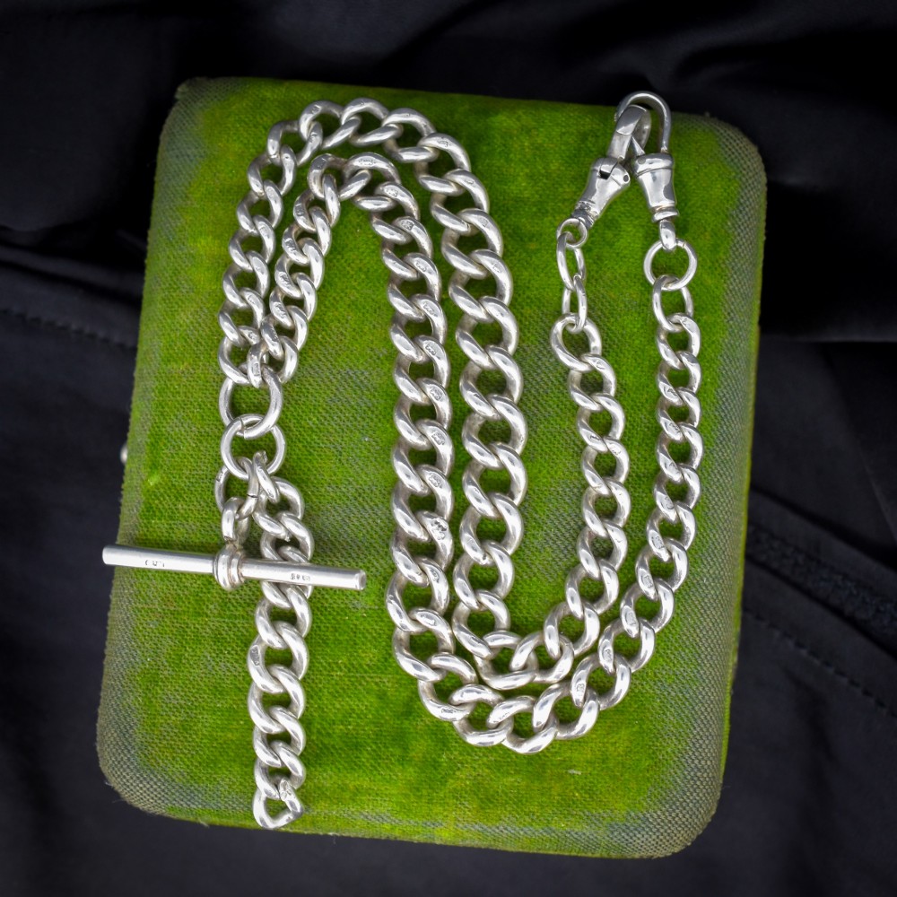 An antique sterling silver curb link Albert chain featuring a central T-bar attachment and double dog clip clasps.
