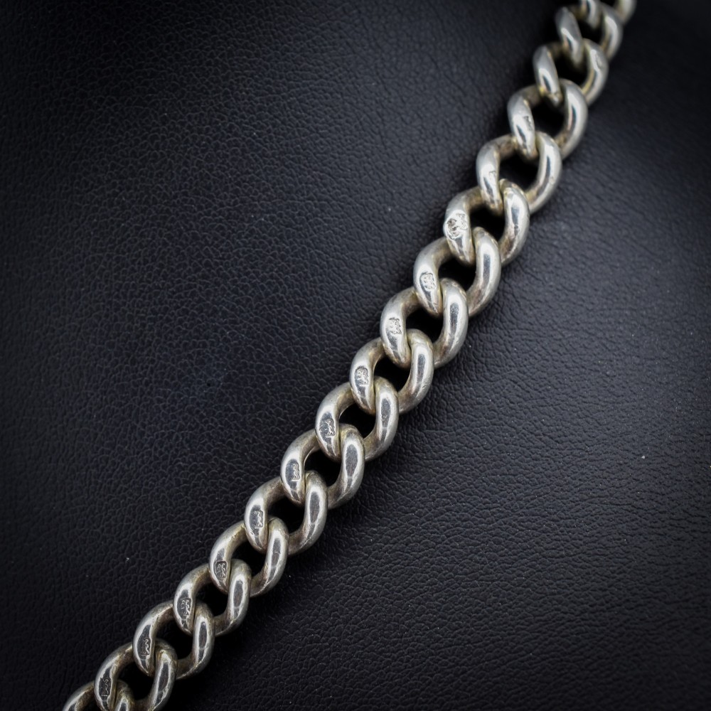 An antique sterling silver curb link Albert chain featuring a central T-bar attachment and double dog clip clasps. View IV