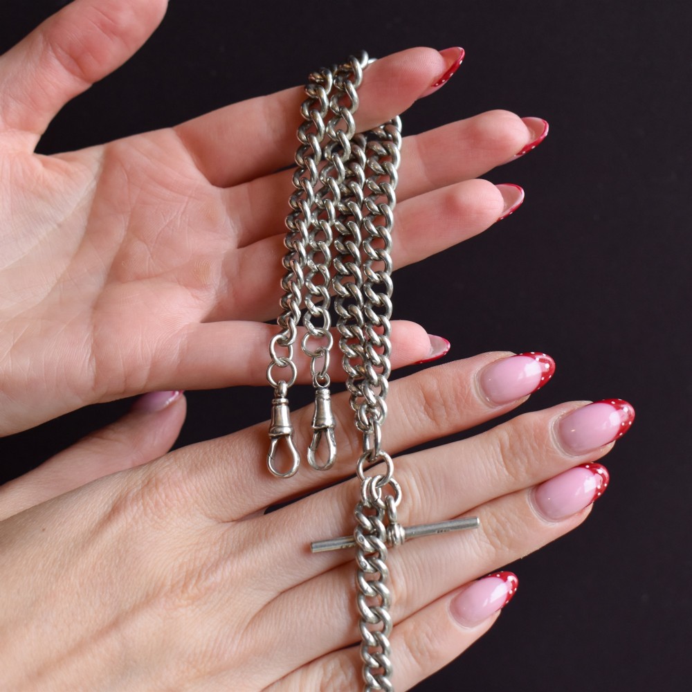 An antique sterling silver curb link Albert chain featuring a central T-bar attachment and double dog clip clasps. View X