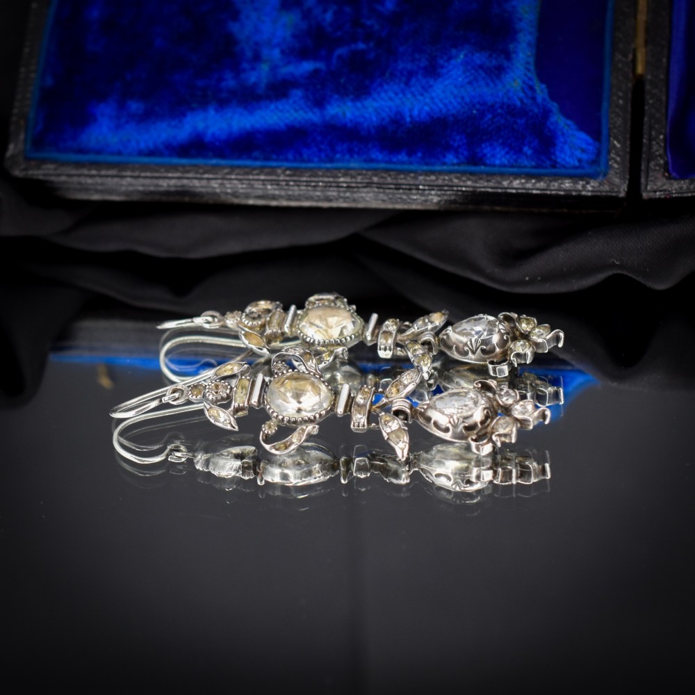 Pair of Georgian silver drop earrings featuring faceted clear rock crystal stones set into articulated silver mounts inside a velvet box. View V