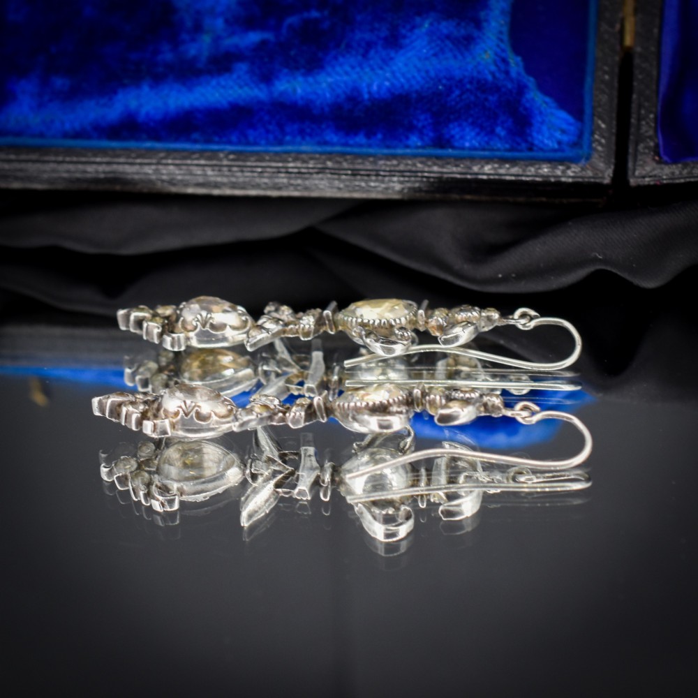 Pair of Georgian silver drop earrings featuring faceted clear rock crystal stones set into articulated silver mounts inside a velvet box. View VI