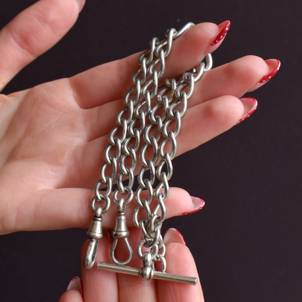 An Edwardian sterling silver Albert watch chain featuring heavy oval links, a central T-bar, and a dog clip clasp. View VIII