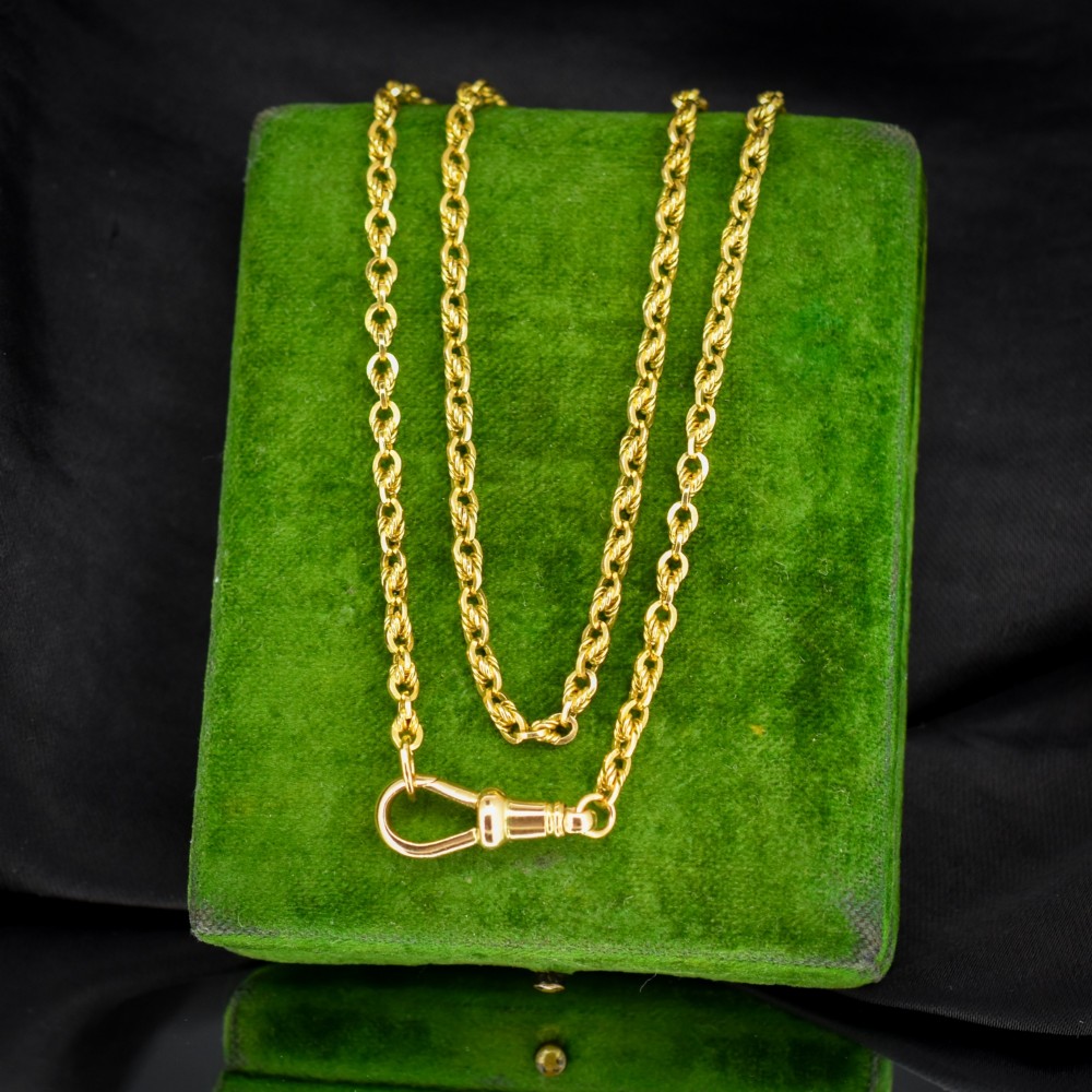 An antique yellow gold twenty-inch chain necklace featuring love knot links and a functional swivel dog clip fastener.