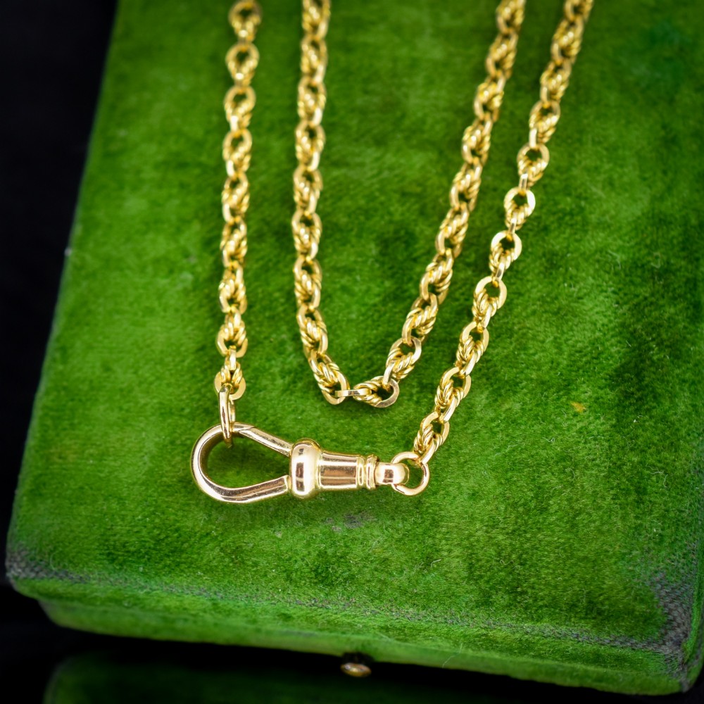 An antique yellow gold twenty-inch chain necklace featuring love knot links and a functional swivel dog clip fastener. View VII
