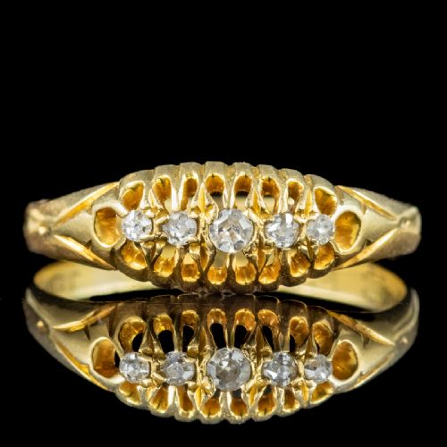 fig 1. An Edwardian yellow gold band featuring a carved openwork gallery set with five graduated round diamonds.