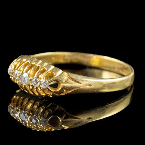 fig 2. An Edwardian yellow gold band featuring a carved openwork gallery set with five graduated round diamonds.