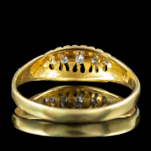 fig 3. An Edwardian yellow gold band featuring a carved openwork gallery set with five graduated round diamonds.
