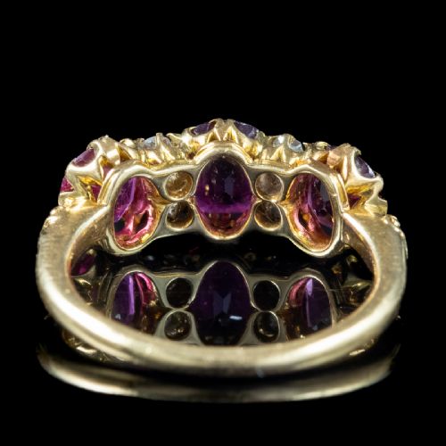 fig 1. A Victorian yellow gold ring featuring three oval red rubies separated by pairs of small round white diamonds set in a carved scroll mount.