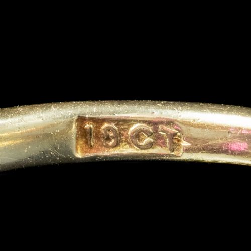 fig 2. A Victorian yellow gold ring featuring three oval red rubies separated by pairs of small round white diamonds set in a carved scroll mount.