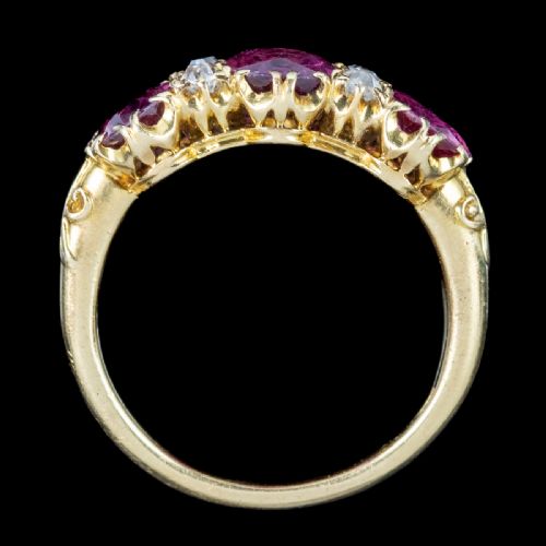 fig 3. A Victorian yellow gold ring featuring three oval red rubies separated by pairs of small round white diamonds set in a carved scroll mount.