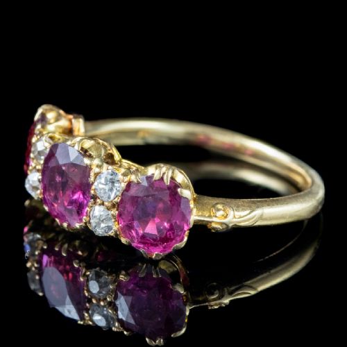 fig 4. A Victorian yellow gold ring featuring three oval red rubies separated by pairs of small round white diamonds set in a carved scroll mount.