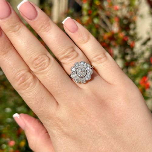 fig 1. An Edwardian platinum ring featuring a large old European cut central diamond surrounded by nine round diamonds forming a daisy cluster.