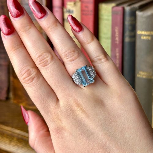 fig 1. A vintage 1950s cocktail ring featuring a large emerald-cut blue aquamarine flanked by stepped shoulders set with round diamonds.