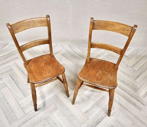 A pair of antique warm brown wooden barback kitchen chairs featuring solid contoured seats, double horizontal back rails, and turned legs. View III
