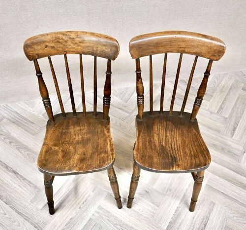 A pair of antique wooden Windsor stickback kitchen chairs featuring curved crest rails, vertical back spindles, shaped seats, and turned legs. View II