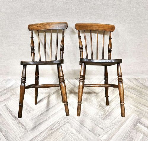 A pair of antique wooden Windsor stickback kitchen chairs featuring curved crest rails, vertical back spindles, shaped seats, and turned legs. View III