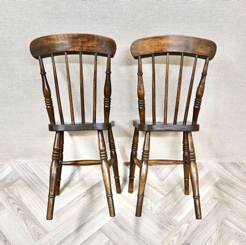 A pair of antique wooden Windsor stickback kitchen chairs featuring curved crest rails, vertical back spindles, shaped seats, and turned legs. View IV