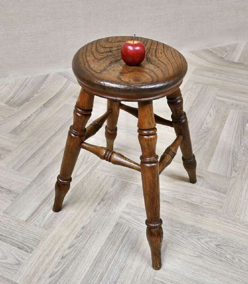 A nineteenth-century turned wooden Windsor stool featuring a circular polished seat supported by four splayed turned legs and turned stretchers. View VI