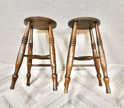 A pair of 19th-century turned wood Windsor stools with round seats, splayed legs, and cross stretchers. View IV