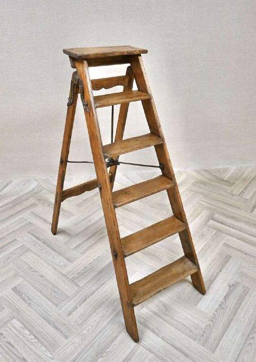 A vintage pine A-frame step ladder featuring wooden treads, iron side braces, and a top platform. View II