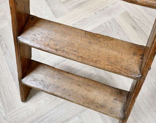 A vintage pine A-frame step ladder featuring wooden treads, iron side braces, and a top platform. View VII