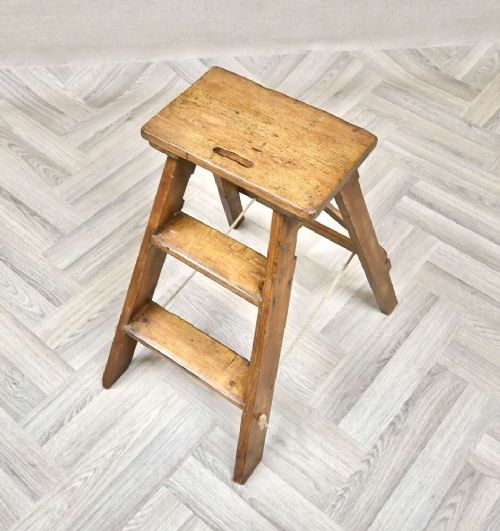 A short folding pine step ladder with three treads, a flat top step, and a rope support brace. View II