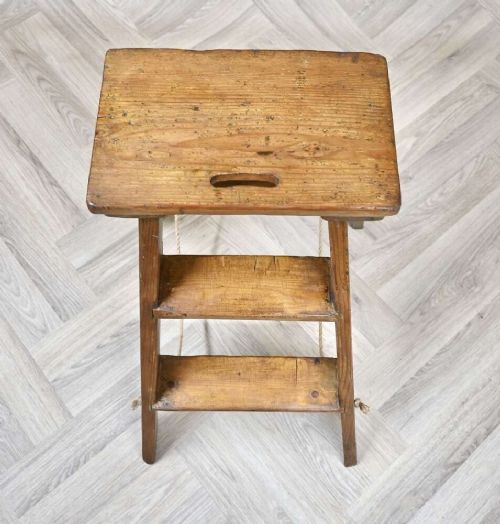 A short folding pine step ladder with three treads, a flat top step, and a rope support brace. View IV