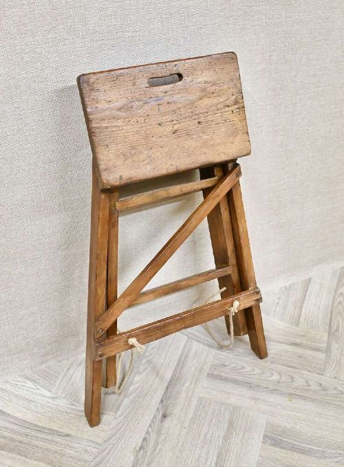 A short folding pine step ladder with three treads, a flat top step, and a rope support brace. View V