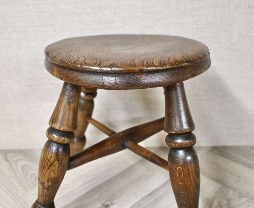 A 19th-century three-legged wooden nursery stool featuring turned legs, cross stretchers, and a circular top. View III