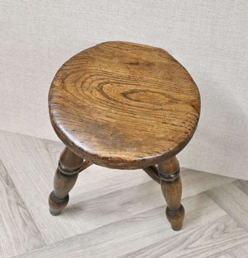 A 19th-century three-legged wooden nursery stool featuring turned legs, cross stretchers, and a circular top. View IV