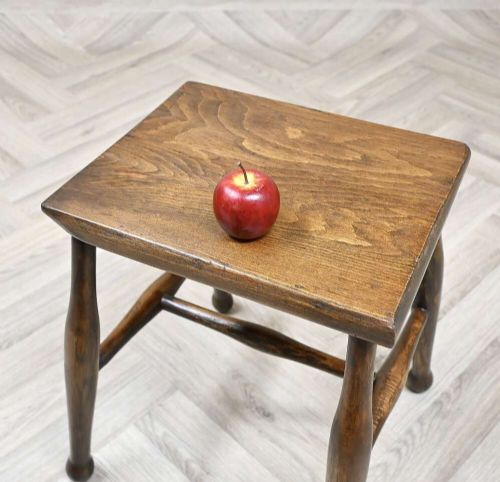 A small rectangular dark timber antique dairy stool featuring four turned legs joined by cross stretchers. View V