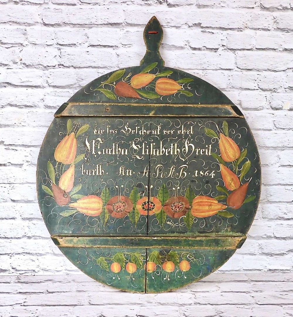 A circular dark green painted wooden board featuring nineteenth century calligraphic inscriptions and hand-painted pear motifs.